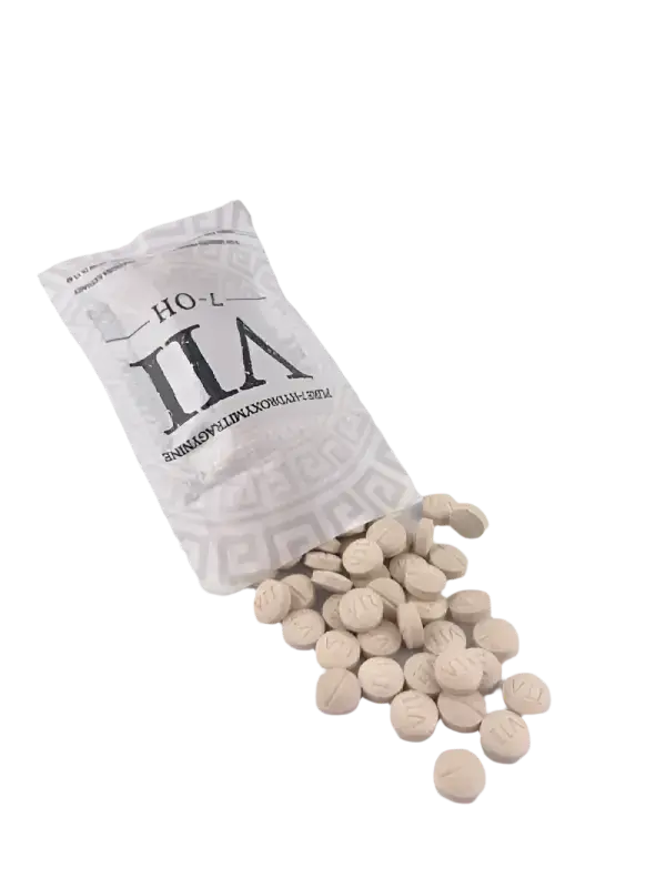 White tablets or pills spilling from a silver-gray packet labeled ’ILA’.